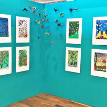 Origami birds hang from the Collective Nouns display.