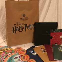 MuggleNet ACoHP swag bag contents: Warner Bros. Studio Tour London – The Making of Harry Potter bag, Audible.com puzzle pieces and box, 4 House journals from the “Harry Potter: Hogwarts Mystery” mobile game, 4 ACoHP MinaLima exclusive buttons, 2 MinaLima Lunar Loop signed art, 1 MinaLima Skiving Snackbox signed art, 1 MinaLima Screaming Yo Yo signed art