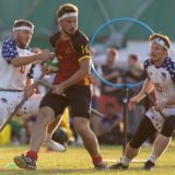 Chaser Andrew Axtell attempts to strip away the Quaffle from Belgium with Luke Langlinais on his right, during USA vs. Belgium