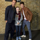 A lucky little Gryffindor gets her photo taken with Law and Redmayne at Platform 9 3/4.