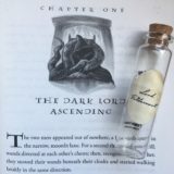 Lord Voldemort’s Pensieve vial lying on top of the first page of Chapter 1, “The Dark Lord Ascending,” in “Harry Potter and the Deathly Hallows”