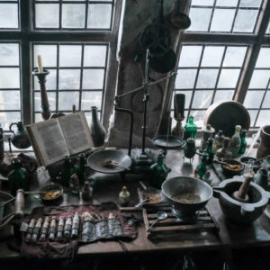 This set photo shows a workstation full of ingredients and magical instruments.