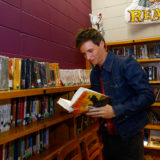 Eddie Redmayne from “Fantastic Beasts: The Crimes of Grindelwald” reads a book as he helps celebrate Wizarding World Day at Parkside Middle School in Baileyton, AL.  (Photo by Butch Dill/Getty Images)