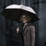 Queenie Goldstein stands in the rain.