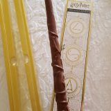 Jelly Belly Hermione Granger chocolate wand, out of the box, with the wizard spell sheet in the background