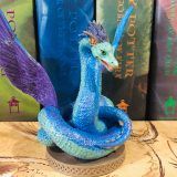 The Occamy figurine is bursting with vivid colors, as shown in this front-facing photograph.