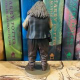 From the back, one can see Hagrid’s wrinkled pants and bushy hair.