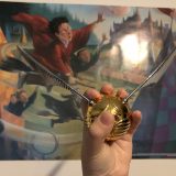 GOLDEN SNITCH™ with Mary GrandPré Quidditch art in the background