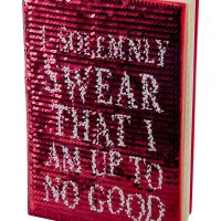 Brushed one way, the sequins reveal a red cover with white text.