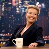 Dame Emma Thompson smiles from behind her desk in this still from “Late Night”.