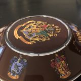 One side of the base has the Ravenclaw and Gryffindor House crests.