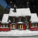 The snow atop The Bradford Exchange’s “HOGWARTS TRAIN STATION™” sparkles in the sunlight.