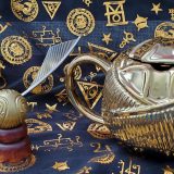 Golden Snitch toy, pictured with the Harry Potter Golden Snitch Coffee Mug from Hallmark Gold Crown