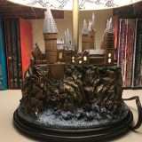 Harry Potter Hogwarts Lamp from The Bradford Exchange: pictured with other Harry Potter collectibles and books, close-up on Hogwarts sculpture base with windows illuminated