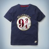 The Mini Boden Platform 9 ¾  Sequin T-shirt in blue features an eye-catching graphic of the circular 9 ¾ sign in silver and red sequins. It retails between £20 and £22.