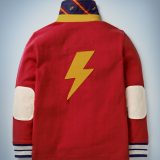 This view of the back of the Mini Boden Hogwarts Rugby Shirt in red showcases a large lightning bolt design. It retails at £30.