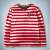 The Mini Boden House Breton in red features all-over red and gold stripes, a blue collar, and “Gryffindor” written in blue script in the front pocket area. It retails between £20 and £22.