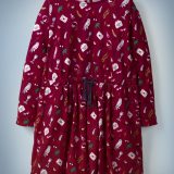 The Mini Boden Hogwarts Printed Dress in red features an all-over pattern of iconic “Harry Potter” images, including Luna Lovegood’s Spectrespecs, Hedwig, and a Hogwarts acceptance letter. The dress features a navy blue drawstring in its center. It retails at £24.