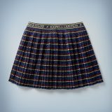 The Mini Boden Spell Skirt is navy blue with red-and-gold stripes and a waistband that features spell incantations such as “Riddikulus” and “Expelliarmus” written in gold and separated by lightning bolts. It retails at £30.