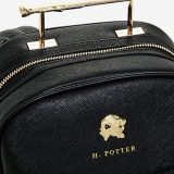 A closer look at the “Harry Potter” wand handle backpack reveals a gold lion’s head, the inscription “H. Potter,” and the handle, created to resemble Harry’s wand.