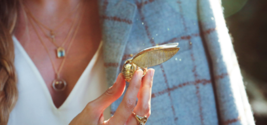 A model is pictured holding a Golden Snitch Ring Box from Freeman Design in the foreground.